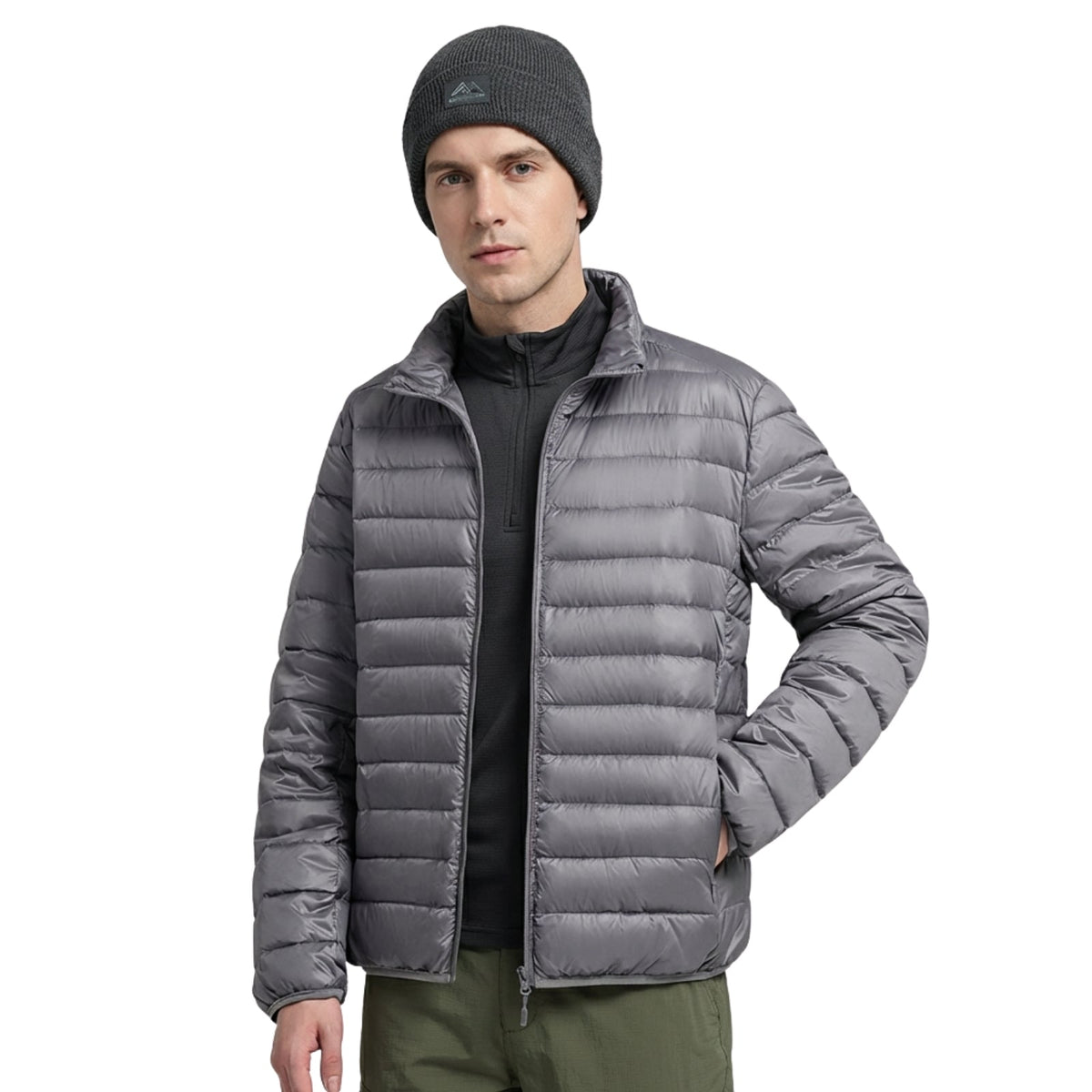 Man wearing the silver grey lightweight puffer jacket open over a black zip-neck top, front view