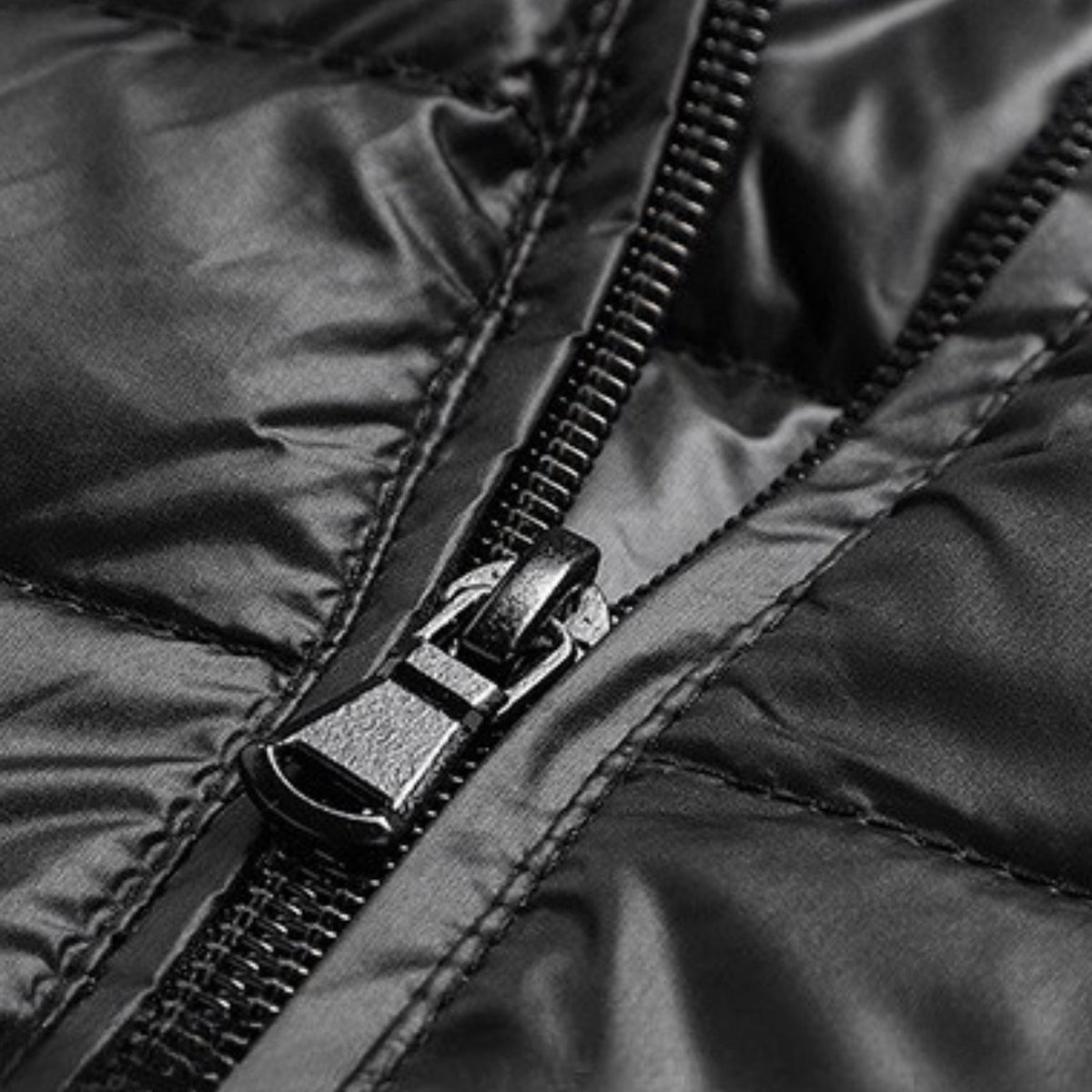 Close-up of the centre zip and quilted shell of the black puffer jacket