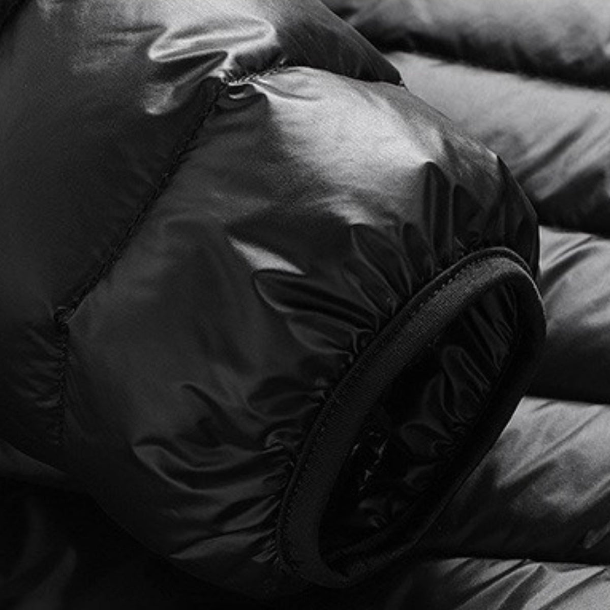 Close-up of the elastic-bound cuff and quilting on the black puffer jacket sleeve