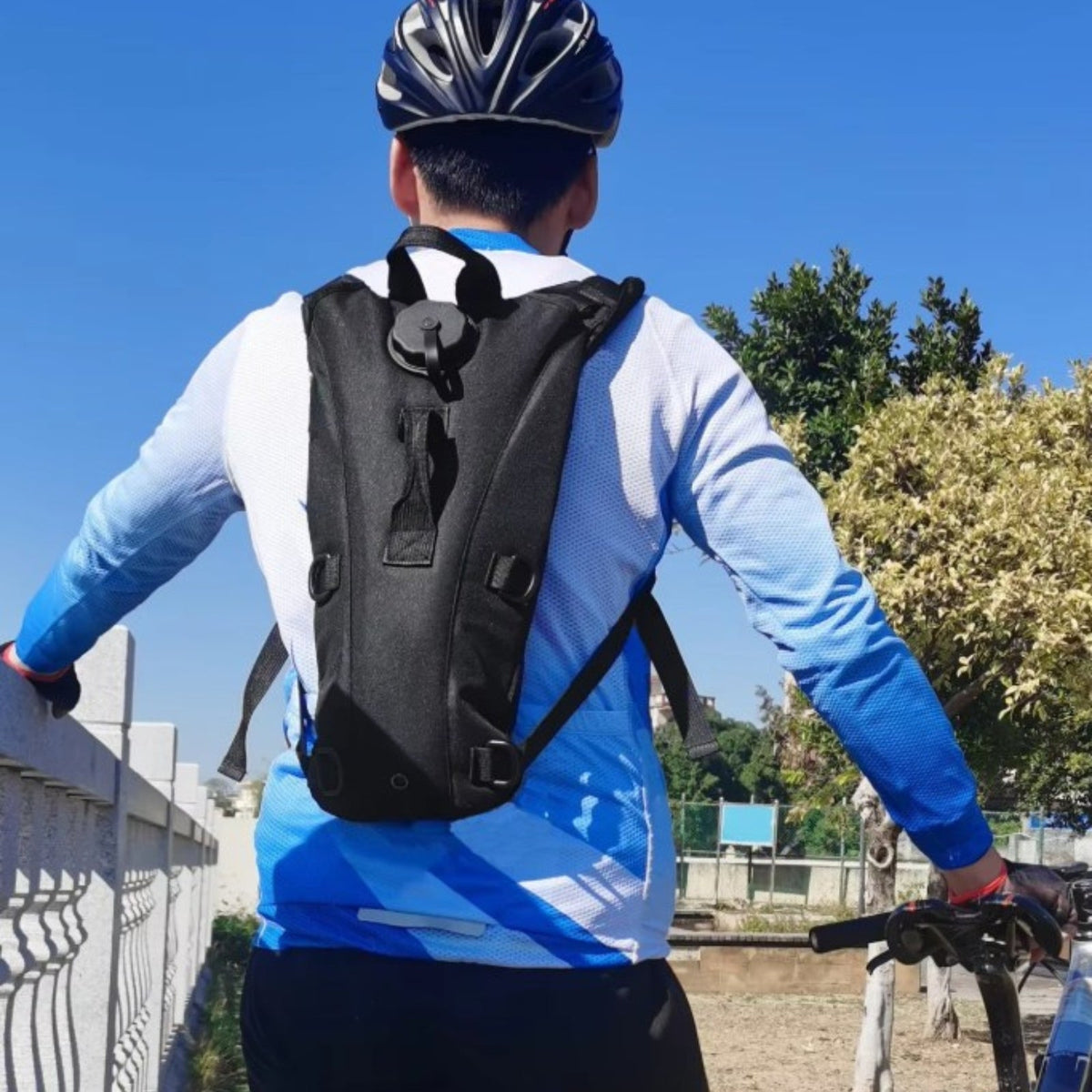 Cyclist seen from behind wearing the black hydration pack