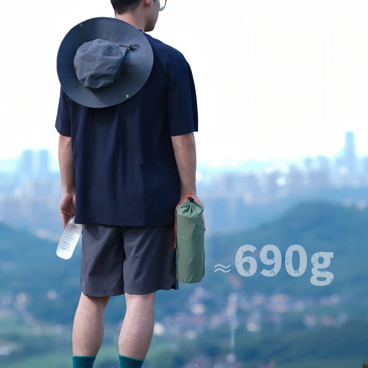 Hiker carrying the packed mat in its green bag, marked about 690 g