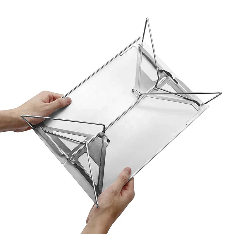 Two hands holding the table underside up, with the wire legs swung out from the back of the brushed metal top.