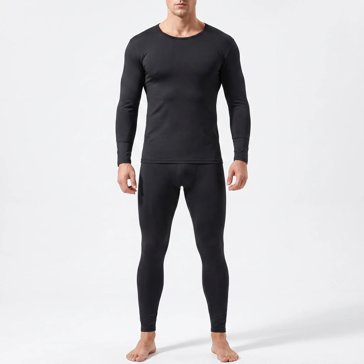 Man wearing the black thermal base layer set, close-fitting crew-neck top and full-length leggings, front view on a light grey background