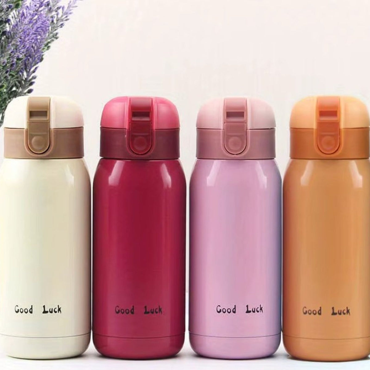 Cream, raspberry, pink and orange insulated bottles in a row