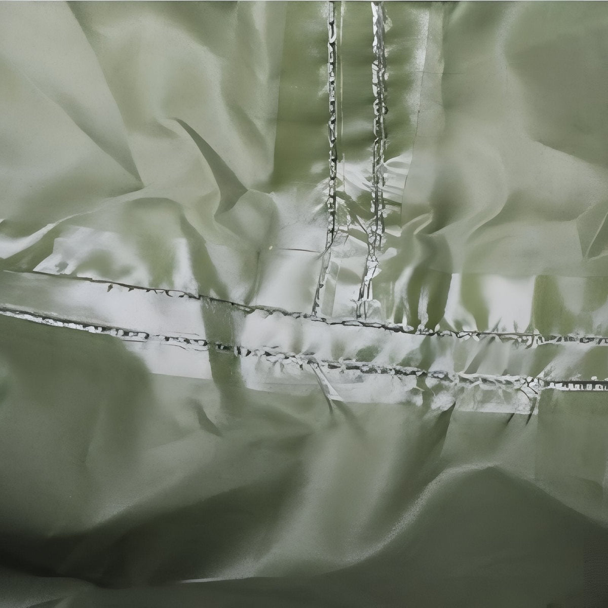Close-up of the olive green poncho fabric with taped seams on the inside