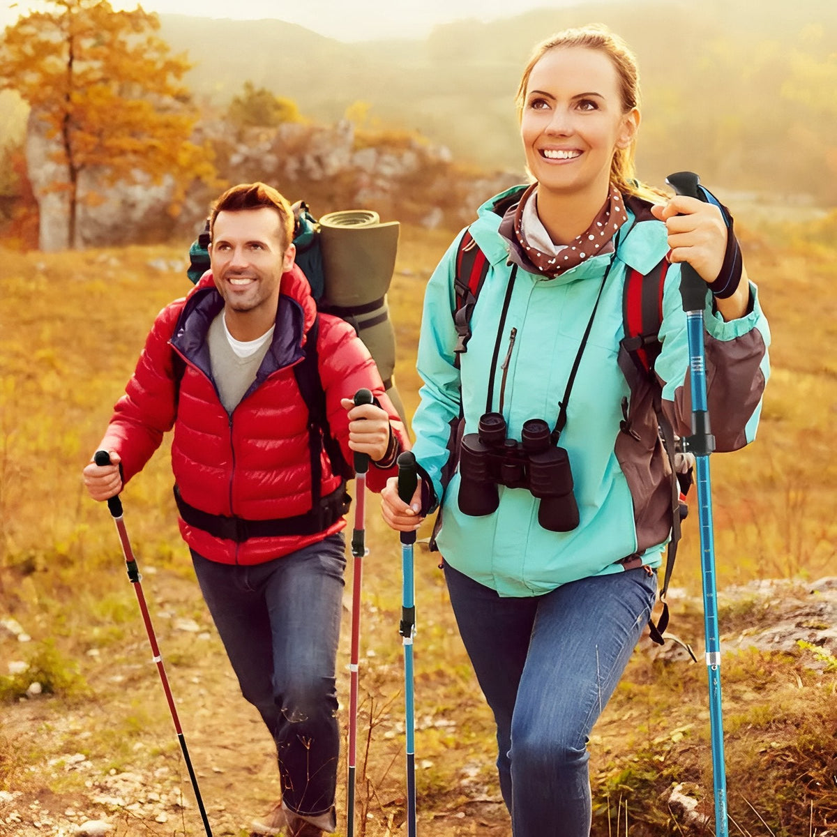 Two hikers walking uphill on an autumn trail with trekking poles