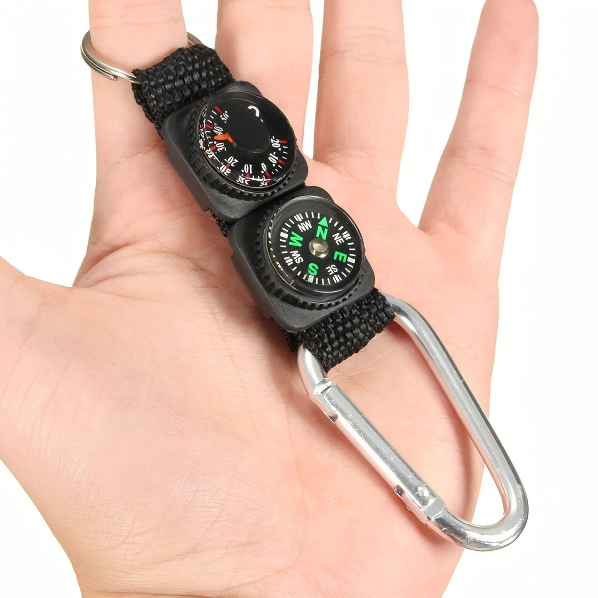 Compass and thermometer keyring lying across an open hand