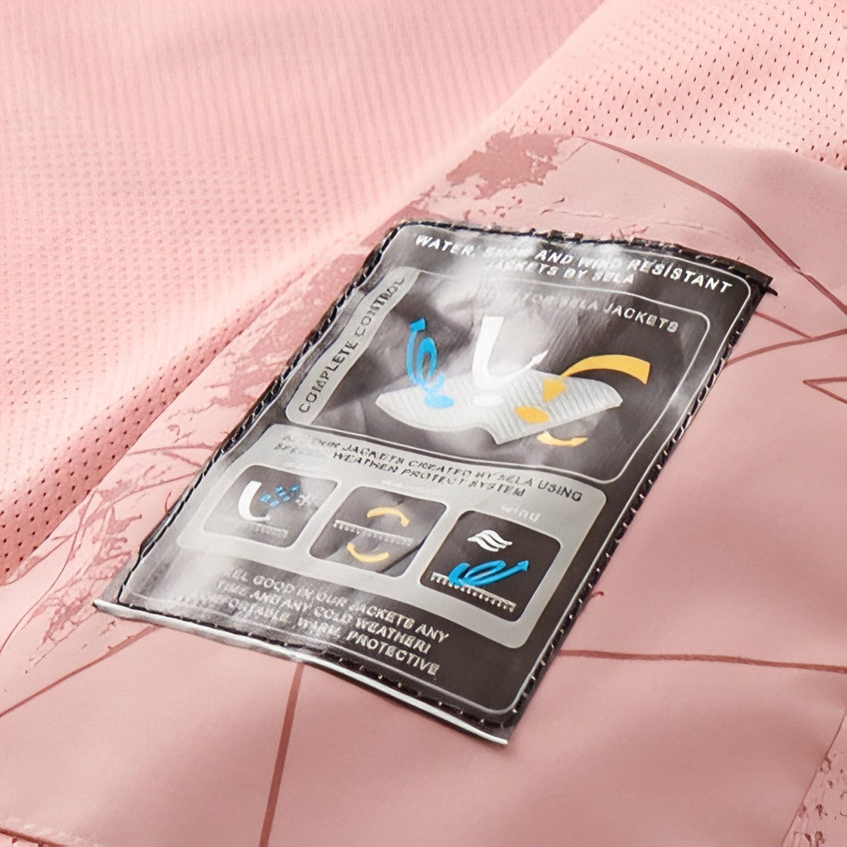 Inside of the pink jacket showing the mesh lining and a sewn-in fabric label