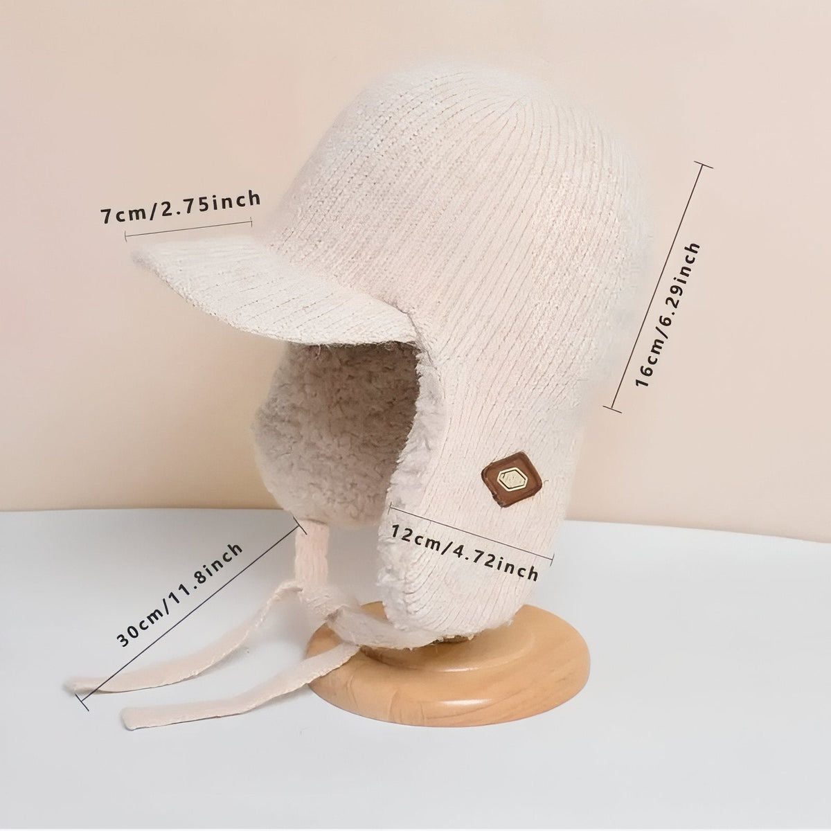 Cream trapper hat marked 7 cm brim, 16 cm tall, 12 cm ear flap and 30 cm tie cord