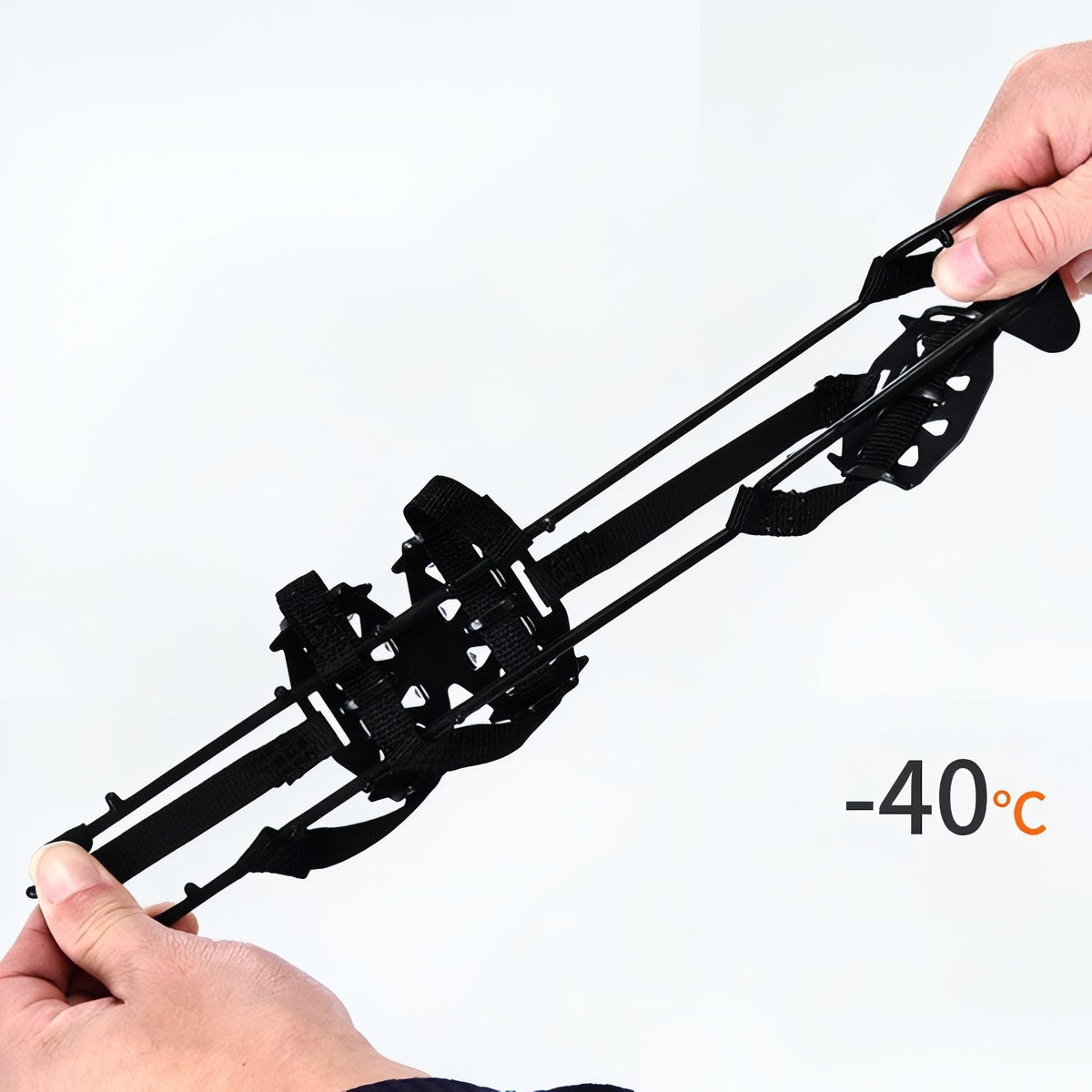 Two hands stretching the black rubber crampon harness to show how far it pulls before fitting over a boot