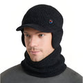 Man wearing the black marl knit winter hat with brim and ear flaps and the matching neck warmer