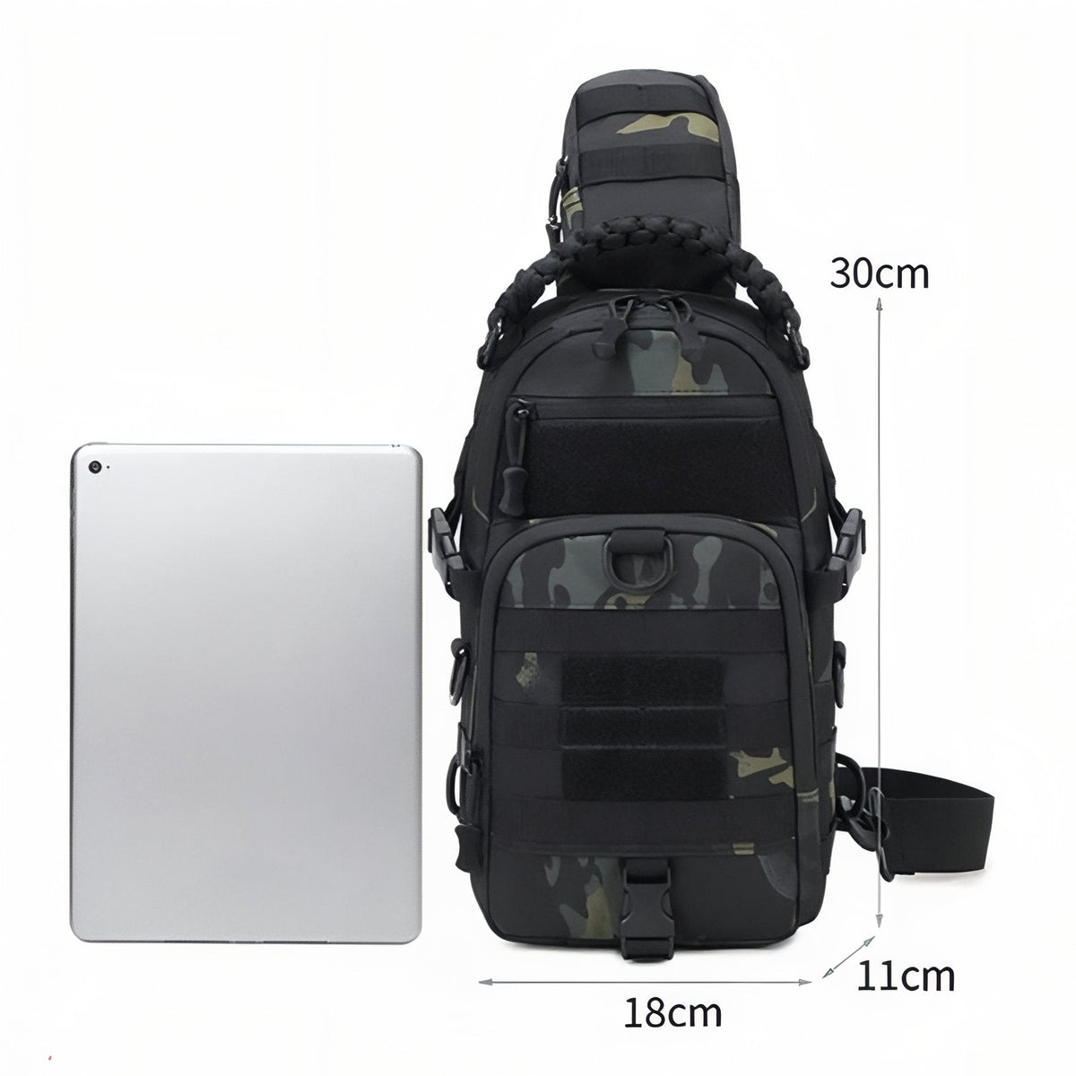Black camouflage sling bag marked 30 cm tall, 18 cm wide and 11 cm deep beside a tablet