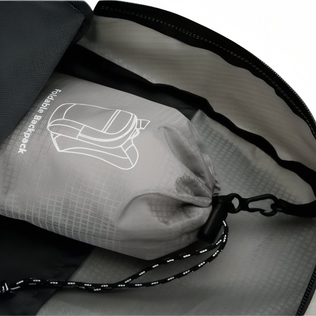Close-up of the grey stuff pouch with its drawstring and cord lock, tucked inside the open pack