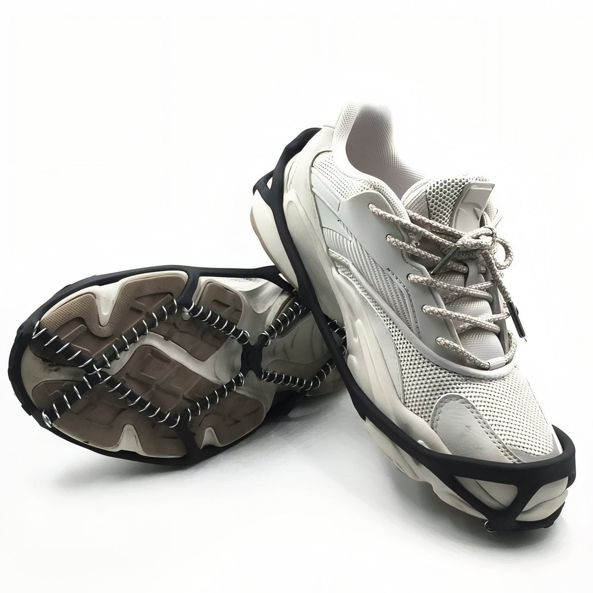 A pair of white trainers fitted with the black coil ice grips