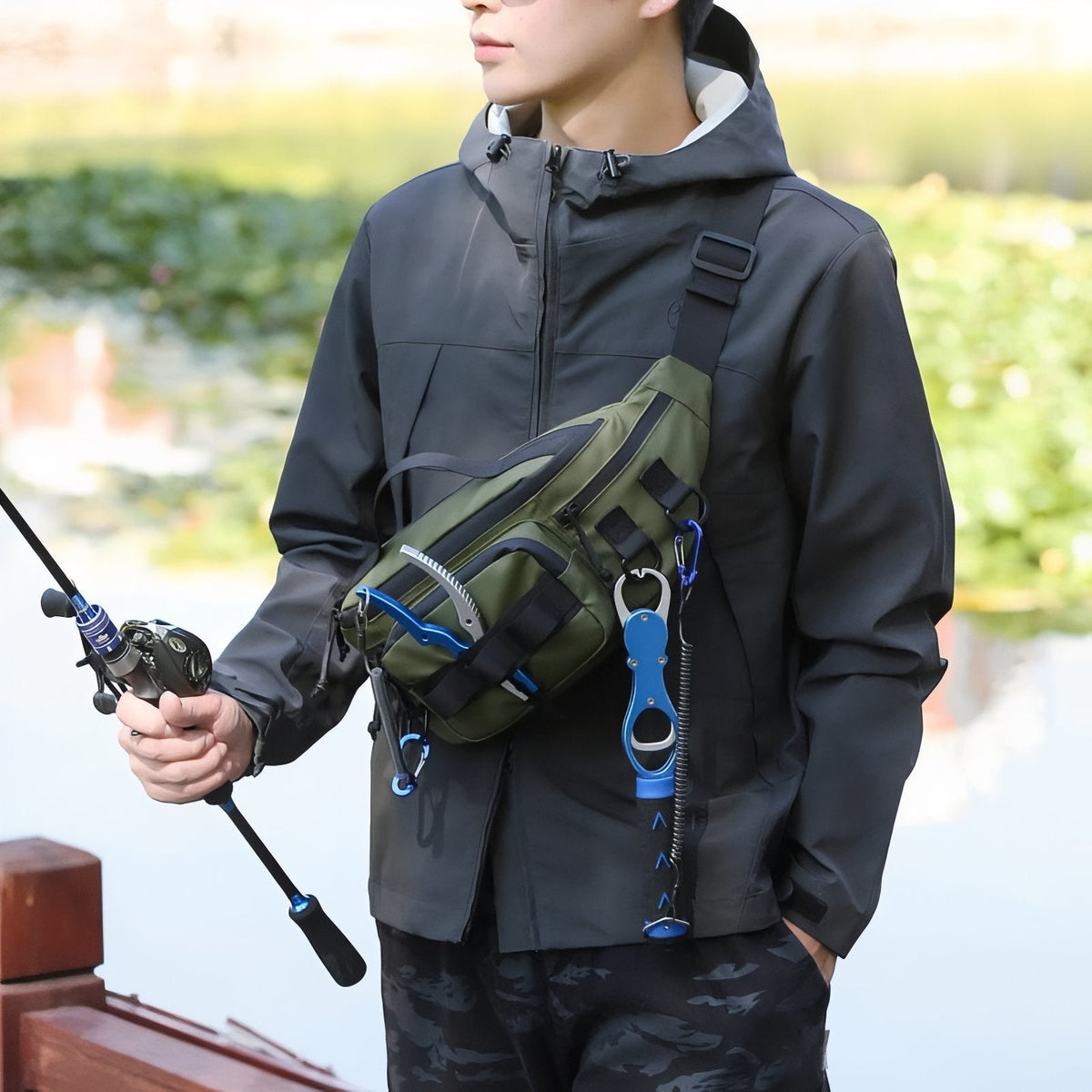 Angler wearing a green and black hip pack across his chest while holding a fishing rod