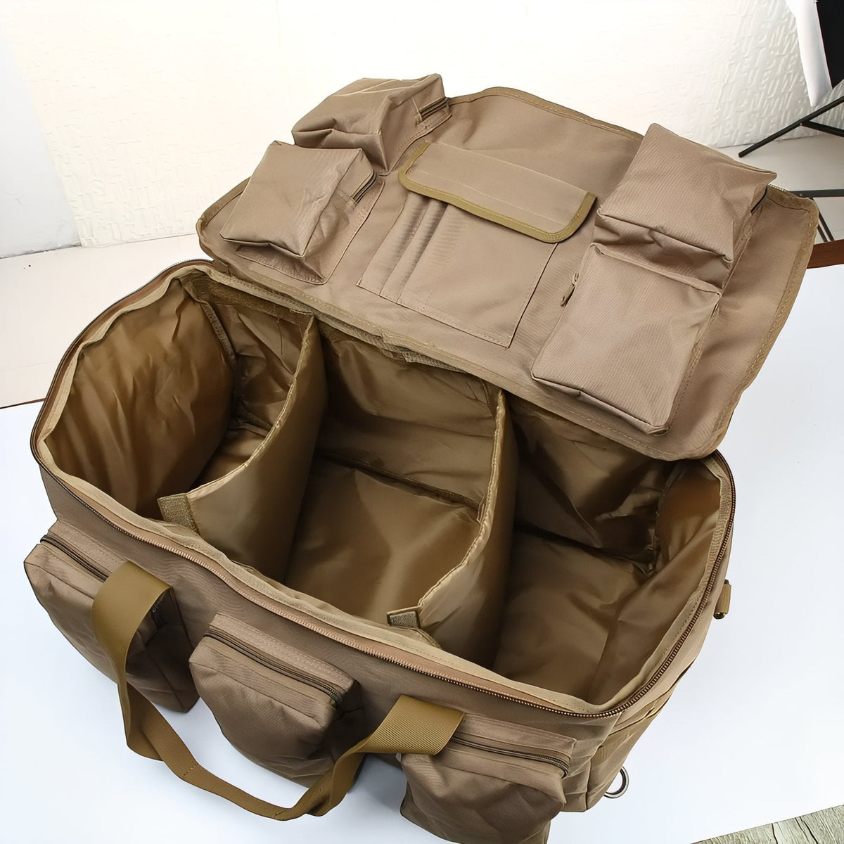 The duffel open, showing fabric dividers inside the main compartment