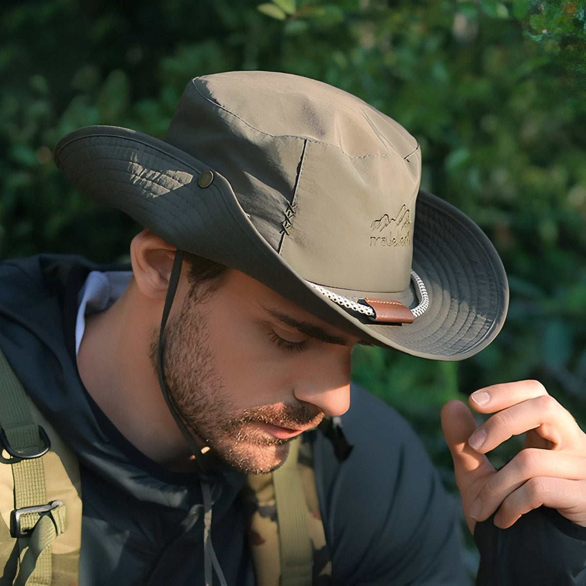 Man in the woods wearing the wide brim hiking hat with one side of the brim snapped up