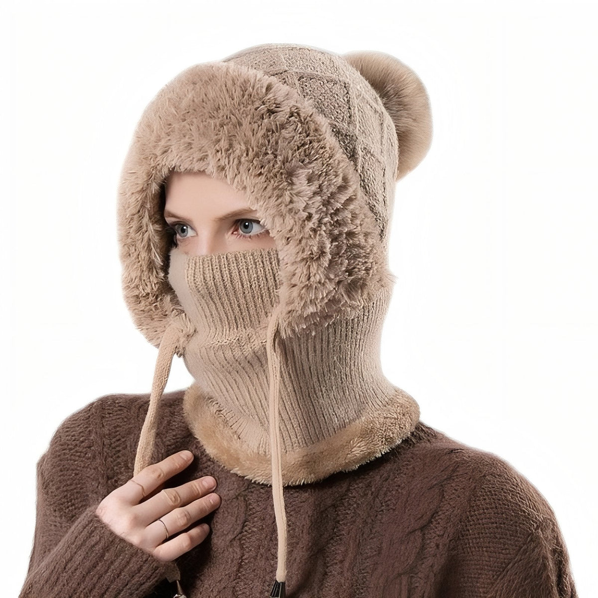 Woman wearing the brown knitted balaclava hood with faux-fur face surround, mask pulled over the nose and pompom on top