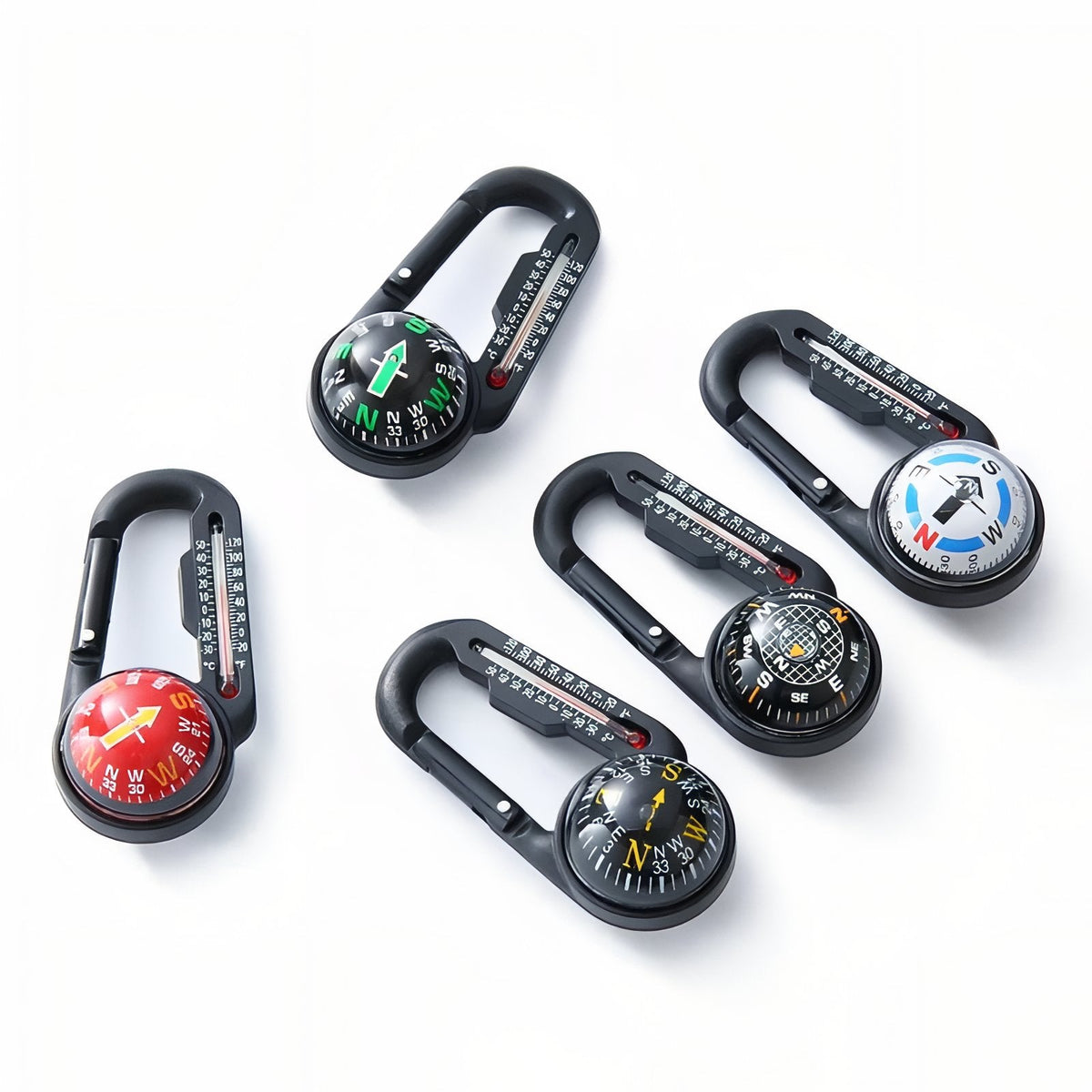 The compass carabiner in five dial colours lying on a white surface