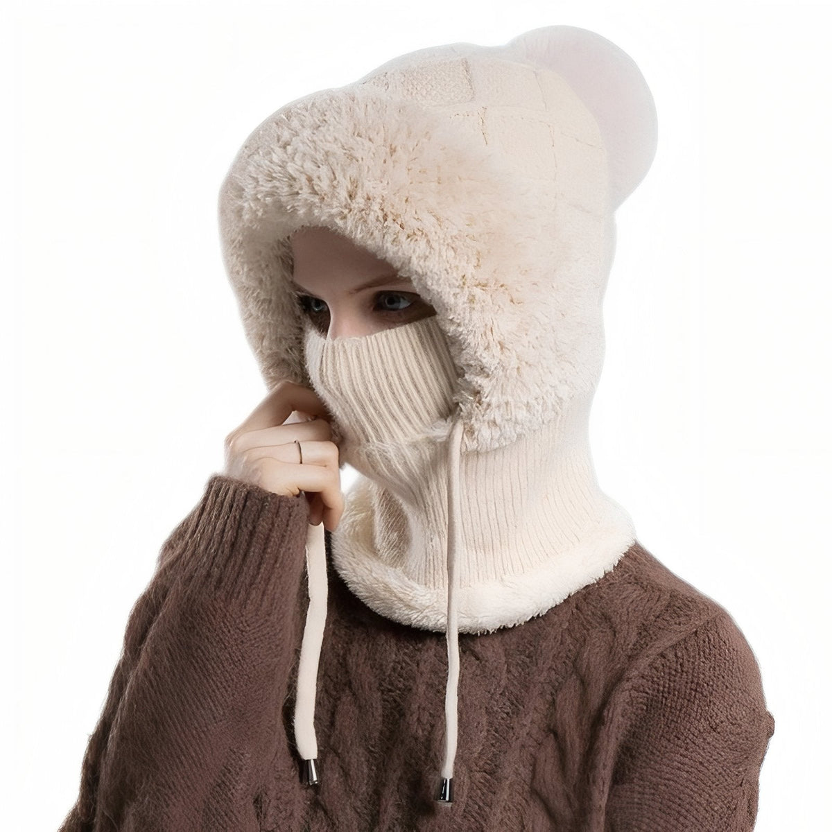 Woman wearing the beige balaclava hood, pulling the rib-knit mask up over her nose