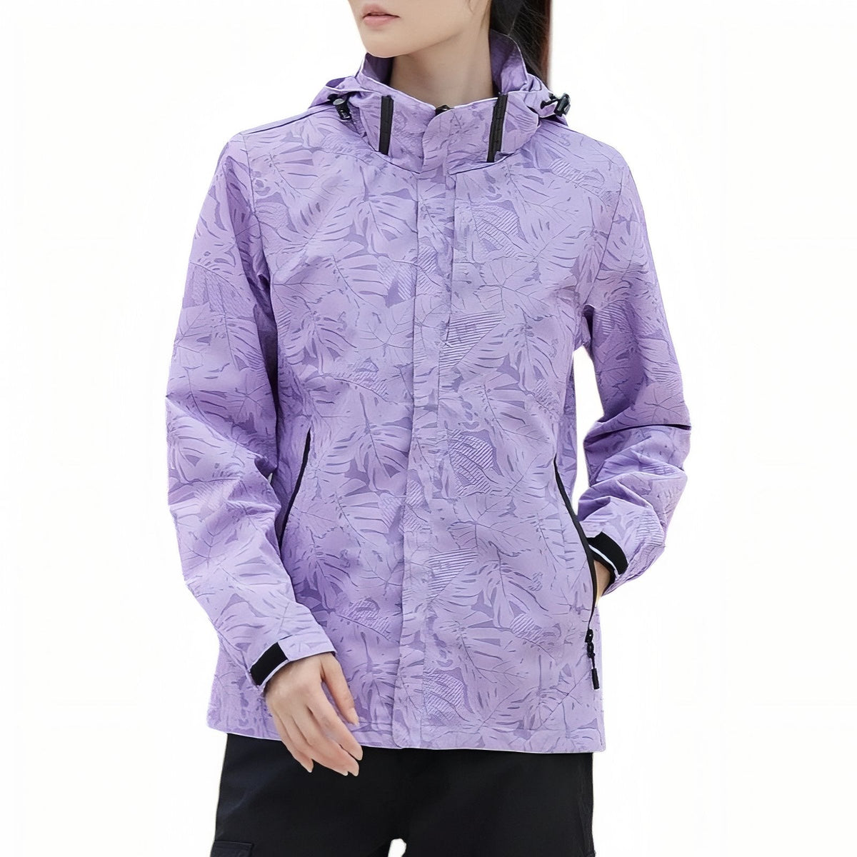 Woman wearing the lilac leaf-print hooded hiking jacket zipped up