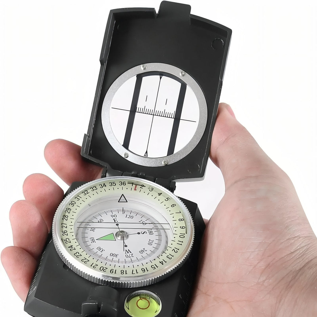 Hand holding the open lensatic compass with its sighting window, dial and bubble level