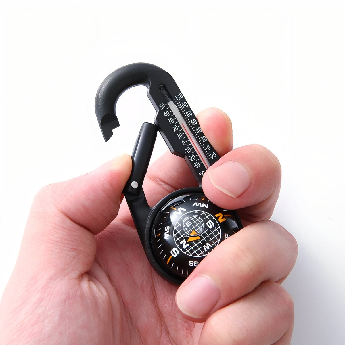 Hand holding the compass carabiner, showing its size against the fingers