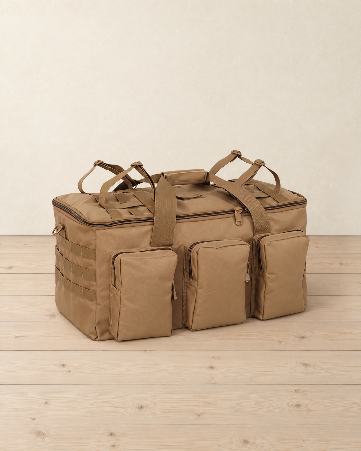 Coyote brown 55 L tactical duffel bag on a pale pine floor, with three zipped front pockets, webbing loops on the end and carry straps on the lid