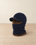 Navy blue knitted balaclava with a short brim and brown plush lining standing on pale pine floorboards