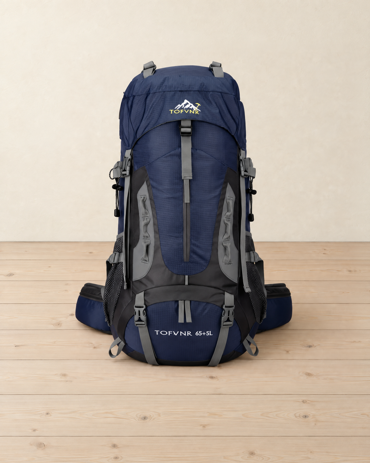 Navy 65 + 5 litre hiking backpack with grey straps, black side panels and a padded hip belt, standing on a pale pine floor