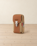 Brown and tan vertical belt pouch with a buckled flap embossed SPORT, standing on a pale pine floor