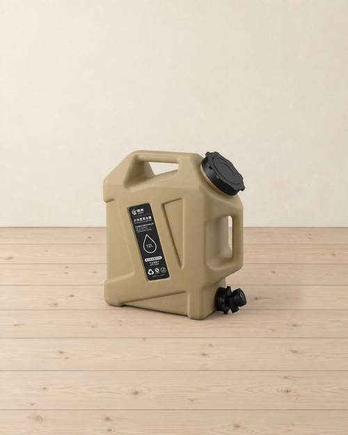 Sand-coloured 12 litre water container with a black screw cap, black tap and black label, standing on a pale pine floor