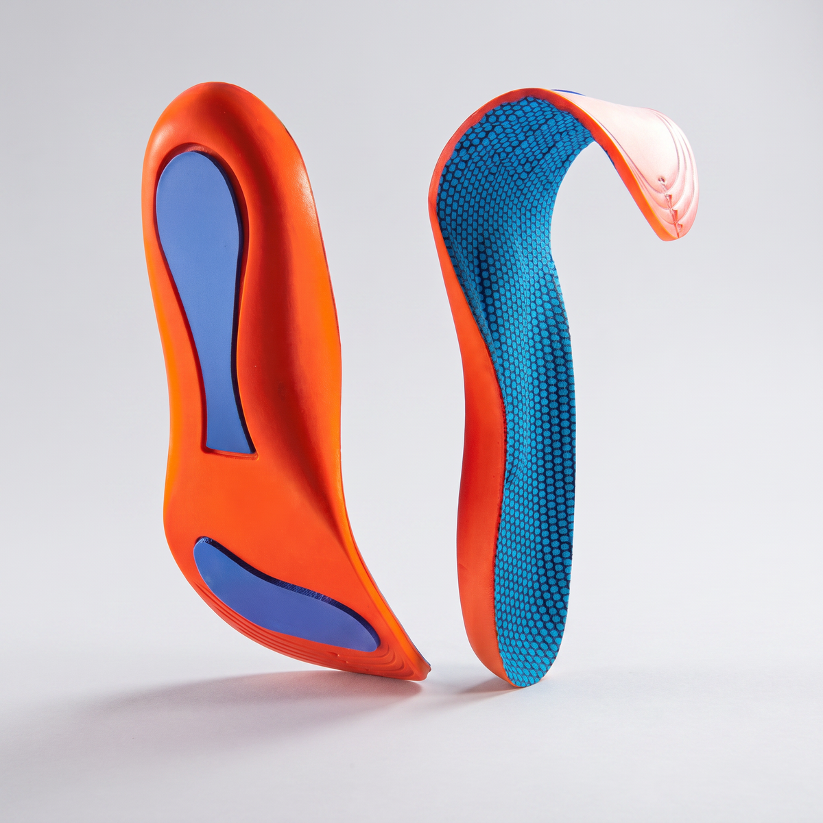 Pair of insoles: the orange underside with blue heel and forefoot pads, and the dimpled blue top face